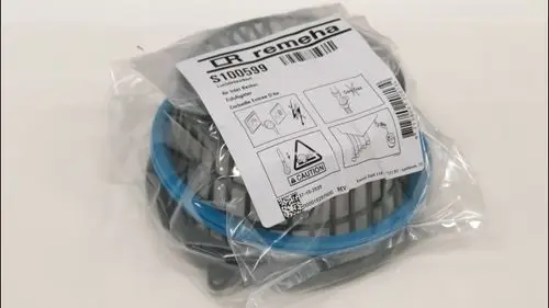 Remeha Zuluftgitter in einer durchsichtigen Verpackung mit blauer Umrandung und Montageanweisungen. Verpackung zeigt Warnhinweise und Verwendungshinweise.
